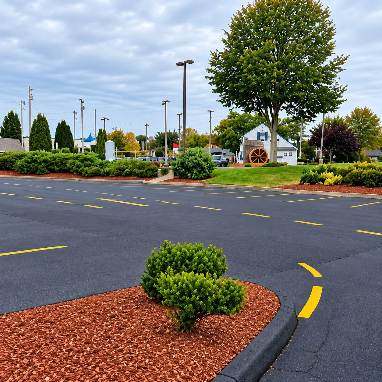 Finished commercial asphalt parking lot with fresh yellow markings and landscaped islands